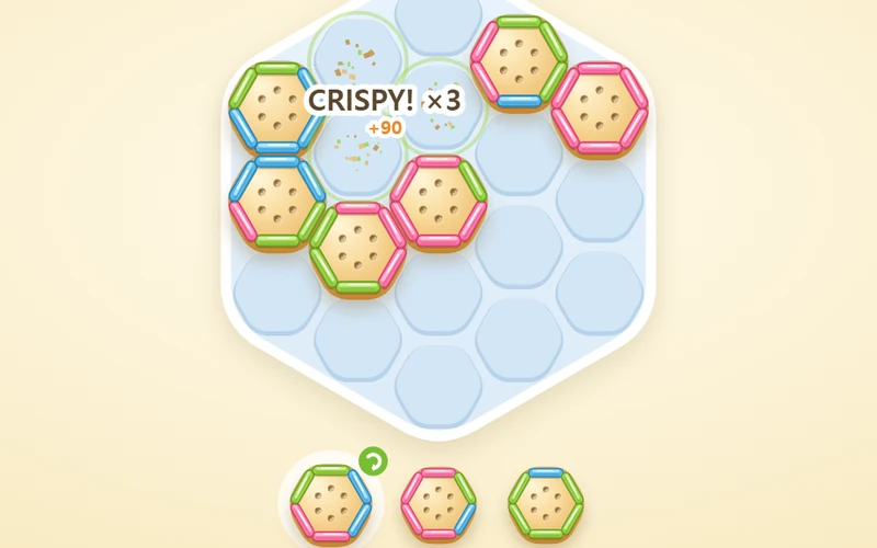 Golden hexagonal crackers with pink, green and sky-blue toppings interlocking on a pale blue tray