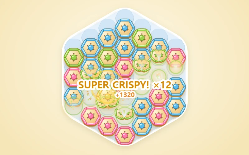 A pale blue hex tray on a cream background, packed with golden hex crackers like a honeycomb. Each cracker has one jam flavor, strawberry, pistachio or blueberry, around its rim and in its center. A group of same-flavor crackers is breaking apart in the middle with crumbs flying, under a SUPER CRISPY! x12 +1320 popup, and a shiny golden cracker sits nearby